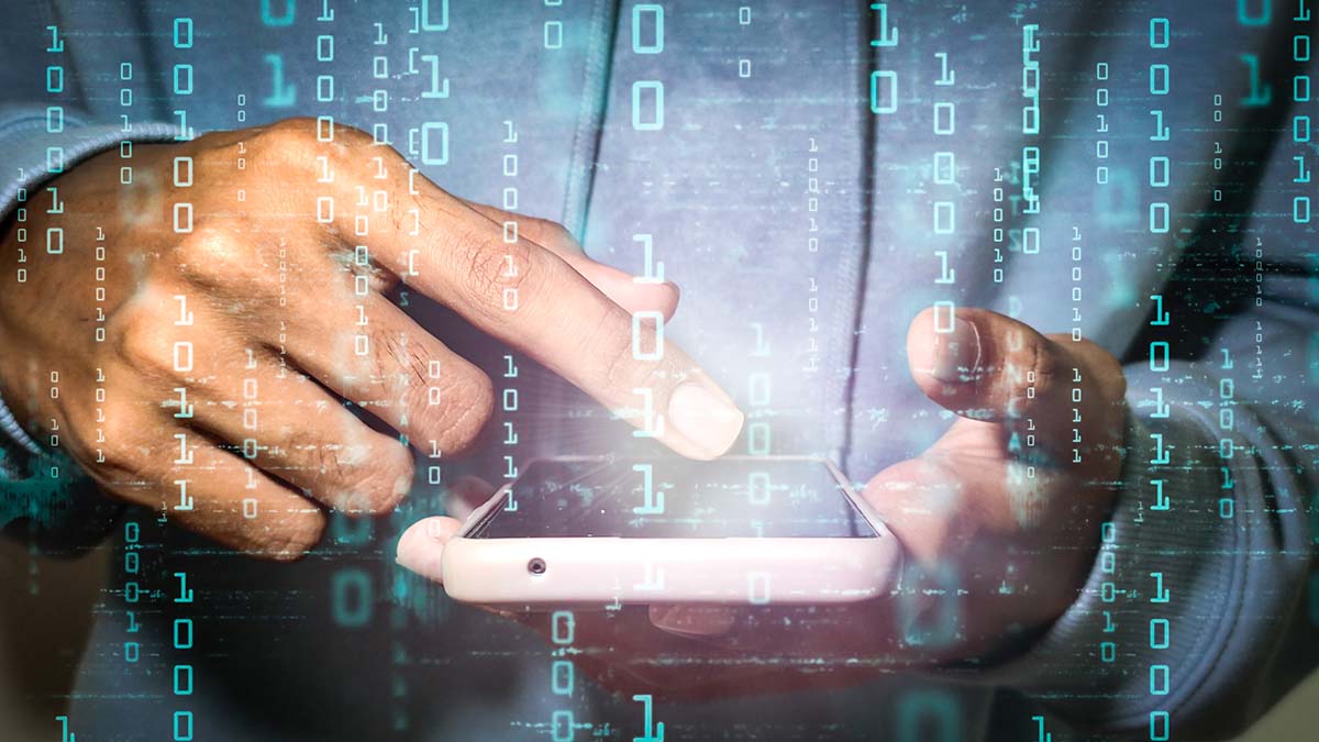 Bild på person som pekar på en mobiltelefon i bakgrunden, i förgrunden av bild syns digitala binära tal.